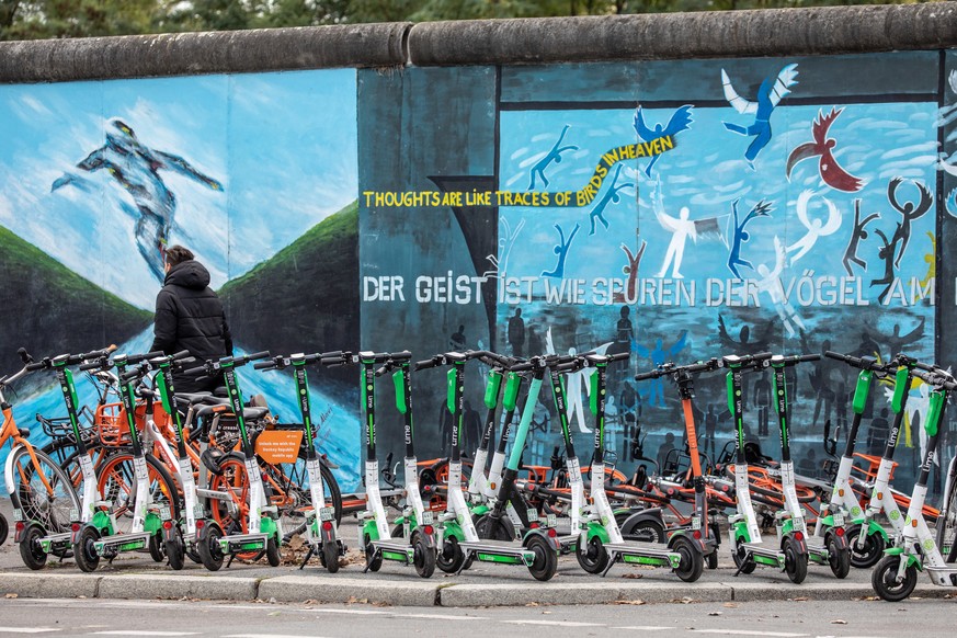 epa07901610 E-scooters from sharing companies park near the East Side Gallery in Berlin, Germany, 06 October, 2019. On 09, November, 2019 the German capital will commemorate the 30th anniversary to th ...