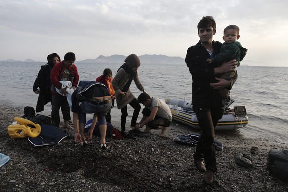 epaselect epa04754644 (06/30) Afghan refugee Zarabkht Safi (R), 20, carries a child after having disembarked at the coast of Kos island, near the sea border with Turkey, Greece, 08 May 2015. According ...