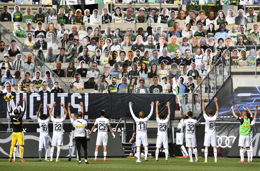 Moenchengladbach players celebrate in front of the cardboards with photos of Moenchengladbach fans displayed on the stands at the end of the German Bundesliga soccer match between Borussia Moenchengla ...