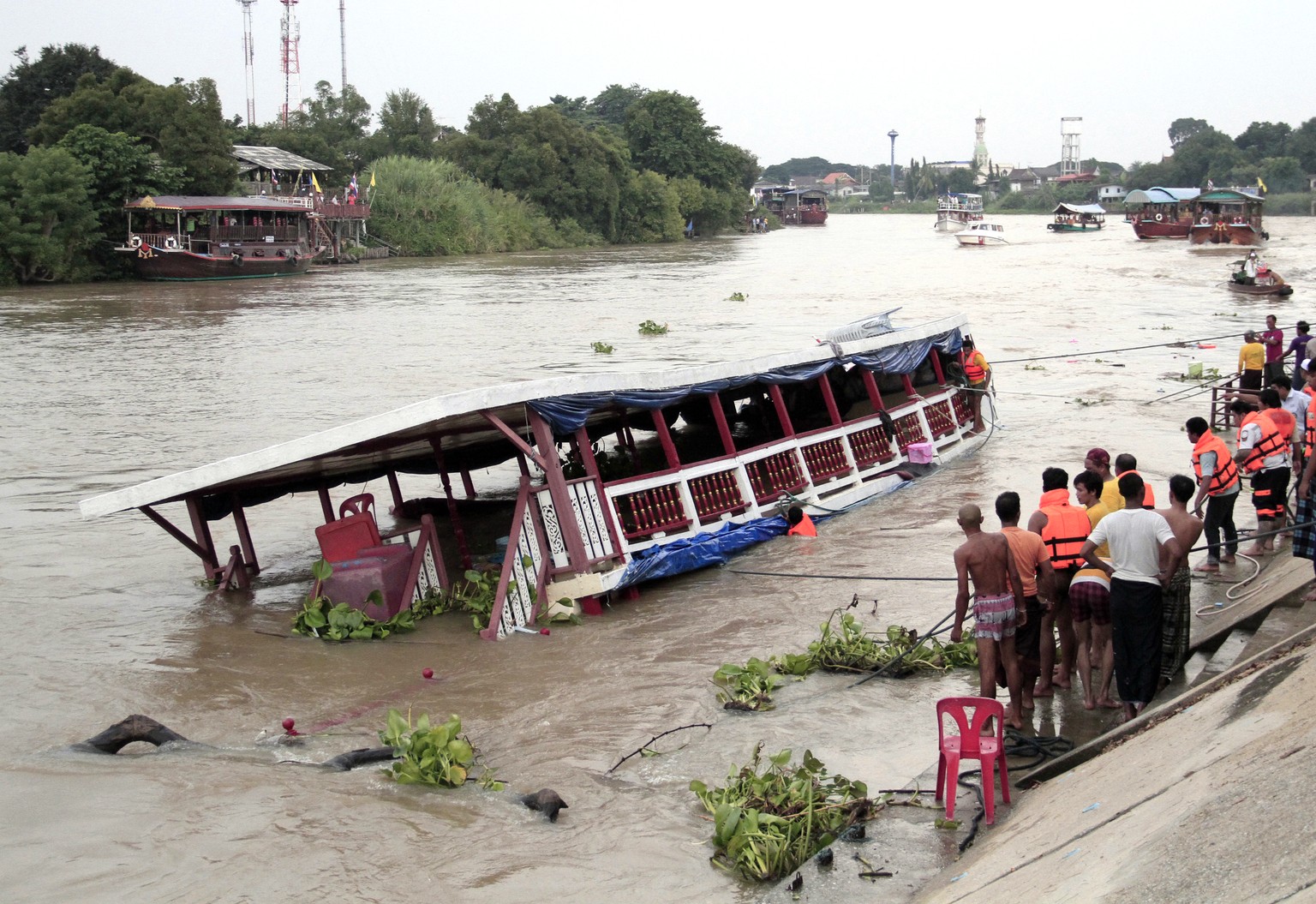 Thai rescue teams search for victims after a boat capsized at Chao Phraya River in Ayuthaya Province, Thailand, Sunday, Sept. 18, 2016. Thai news reports say at least 13 people were killed when a doub ...