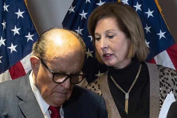 Former Mayor of New York Rudy Giuliani, left, listens to Sidney Powell, both lawyers for President Donald Trump, during a news conference at the Republican National Committee headquarters, Thursday No ...