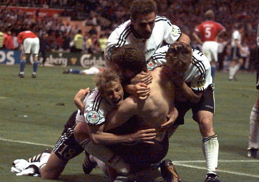 German players fall down to embrace Oliver Bierhoff (without jersey) after he scored the golden second goal for Germany during extra time of the final of the European soccer championships between the  ...