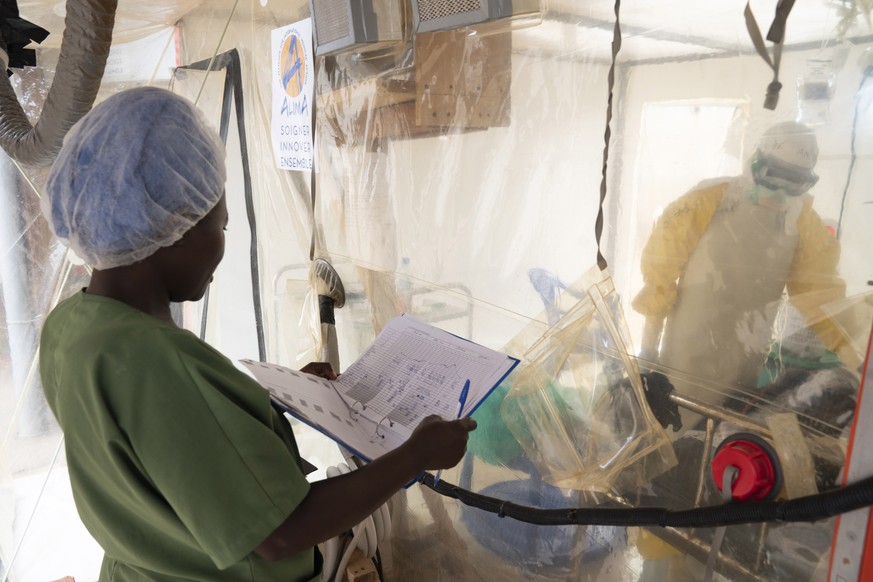 epa07788728 A handout image dated 23 June 2019 and made available by the World Health Organization, WHO, on 23 August 2019 showing Health workers inside a &#039;CUBE&#039; talking to an Ebola patient, ...