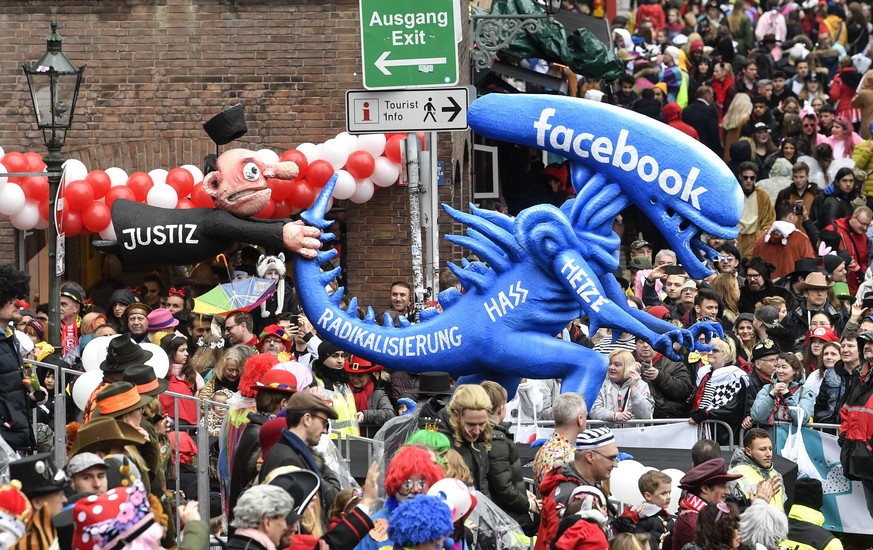A carnival float depicts a Facebook alien running away from justice during the traditional carnival parade in Duesseldorf, Germany, on Monday, Feb. 24, 2020. The foolish street spectacles in the carni ...