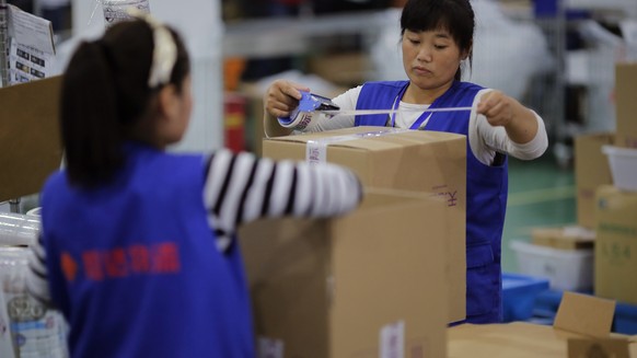 Employees work at an Alibaba Group warehouse on the outskirts of Hangzhou, Zhejiang province October 30, 2014. A trademark spat between Chinese e-commerce giant Alibaba Group Holding Ltd and rival JD. ...