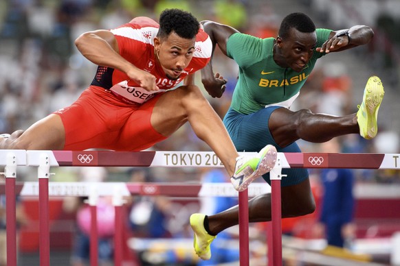 epa09390852 Jason Joseph of Switzerland (L) competes next to Gabriel Constantino of Brazil (R) in the Men&#039;s 110m Hurdles heats during the Athletics events of the Tokyo 2020 Olympic Games at the O ...