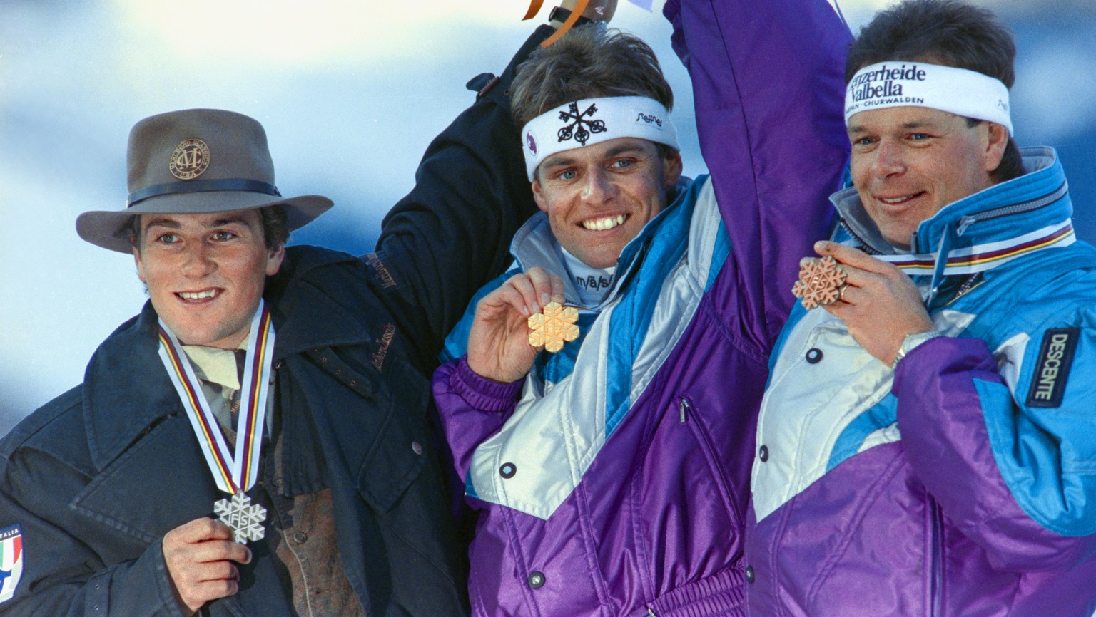 Franz Heinzer, Mitte, gewinnt bei den Alpinen Skiweltmeisterschaften in Saalbach die Abfahrt vor Peter Runggaldier, links, und Daniel Mahrer, rechts, aufgenommen am 27. Januar 1991. (KEYSTONE/Str)