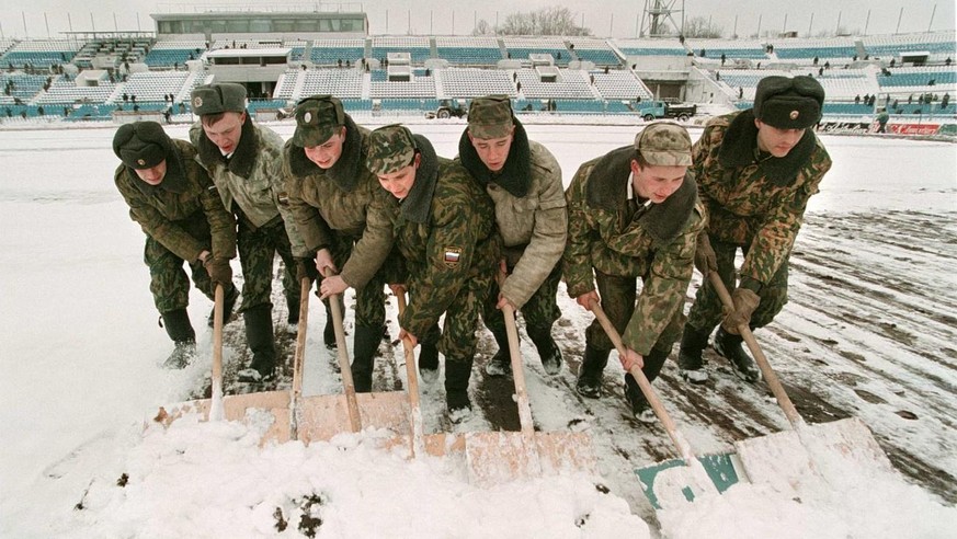 MOS01-19980414-MOSCOW, RUSSIAN FEDRATION - Russian soldiers clean 14 April the field of Moscow&#039;s &quot;Dynamo&quot; stadium from snow as a preparation for the UEFA Cup semi-final second leg match ...