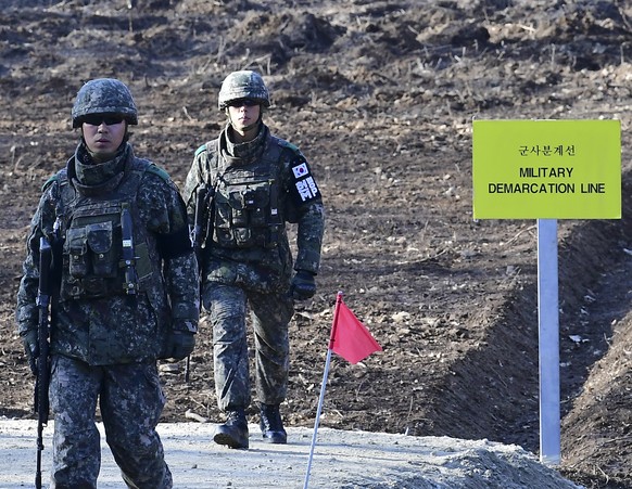South Korean soldiers walk at Arrowhead Ridge, a site of fierce battles in the 1950-53 Korean War, as they build a tactical road across the Military Demarcation Line inside the Demilitarized Zone (DMZ ...