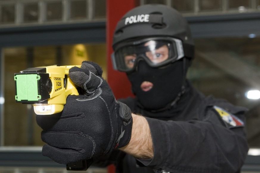 A member of Geneva&#039;s Intervention Group Police demonstrates a Taser X26 electroshock weapon at the Geneva Police headquarters in Geneva, Switzerland, Monday, April 27, 2009. A Taser is an electro ...