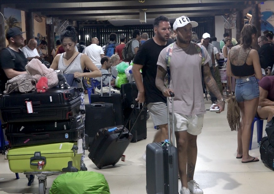epa07260971 Foreign tourists with their belongings wait as their flights to leave the island of Samui have been cancelled following a tropical storm Pabuk weather warning, at an airport of Koh Samui I ...