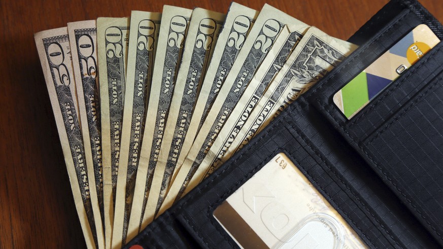 FILE - In this June 15, 2018 file photo, cash is fanned out from a wallet in North Andover, Mass. Only 33% of American adults follow a budget, according to an October 2017 survey of Americans from Ner ...