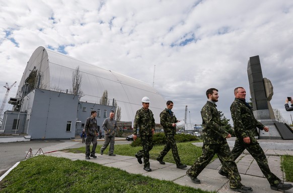 epa05265651 Workers walk next to the construction of a new protective shelter which will be placed over the remains of the nuclear reactor Unit 4, at Chernobyl nuclear power plant, in Chernobyl, Ukrai ...