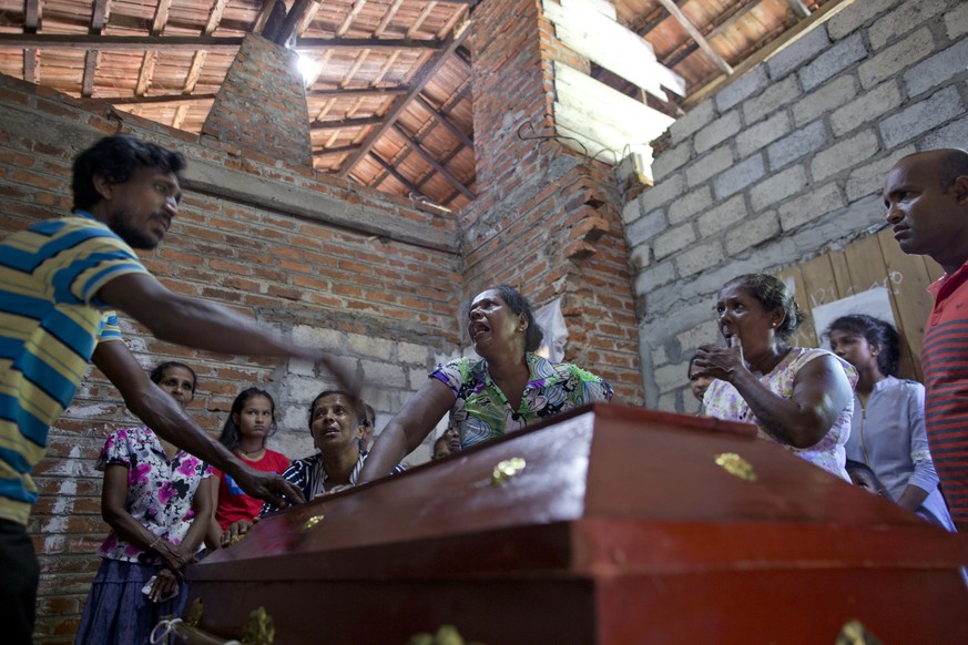 Lalitha, center, argues with a relative on weather to open the sealed-coffin to see her 12-year old niece, Sneha Savindi, who was a victim of Easter Sunday bombing at St. Sebastian Church, in Negombo, ...