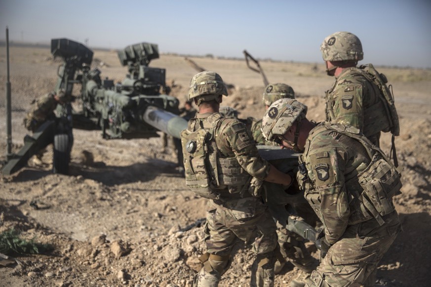 FILE - In this June 10, 2017 photo provided by Operation Resolute Support, U.S. Soldiers with Task Force Iron maneuver an M-777 howitzer, so it can be towed into position at Bost Airfield, Afghanistan ...