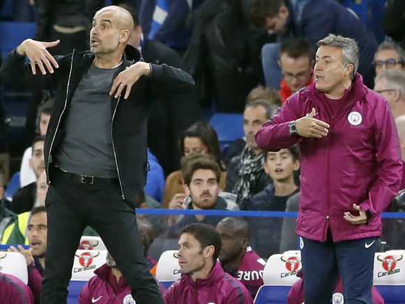 Manchester City coach Josep Guardiola. left, and coaching staff member Domenec Torrent, right, gesture during the English Premier League soccer match between Chelsea and Manchester City at Stamford Br ...