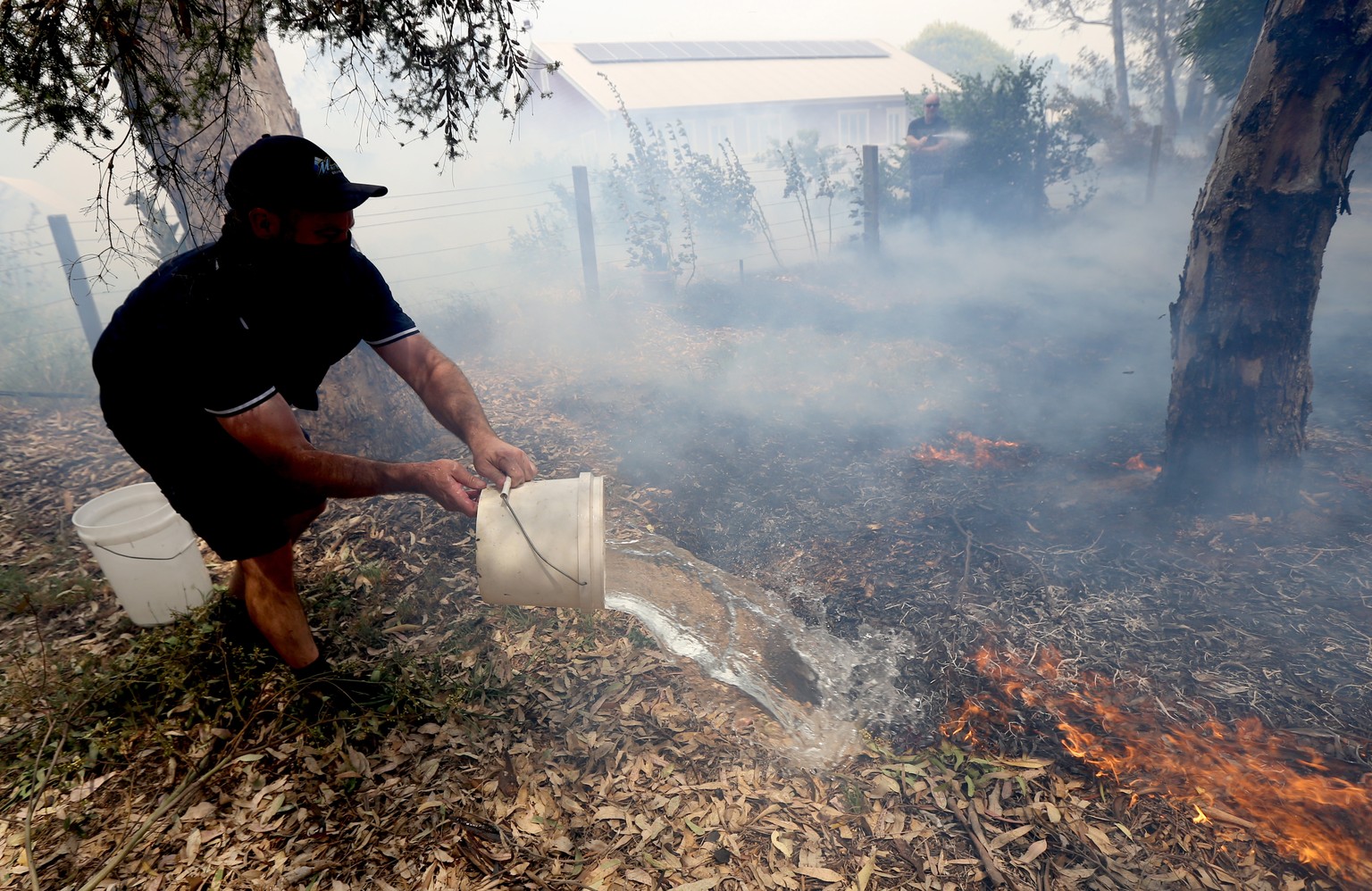 epa08084547 Residents put out spot fires on Station Road in Woodside in the Adelaide Hills in Adelaide, South Australia, Australia, 20 December 2019 (issued 21 December 2019). Fires are burning at eme ...