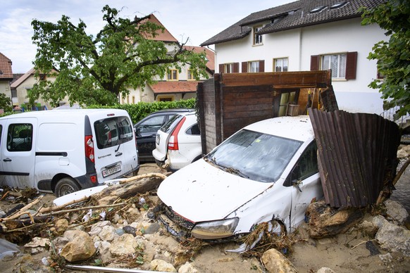epa09294944 Car wrecks are pictured after a strong storm in Cressier, Switzerland, 23 June 2021. On the evening of 22 June severe weather conditions caused the Ruhault to flood and caused significant  ...