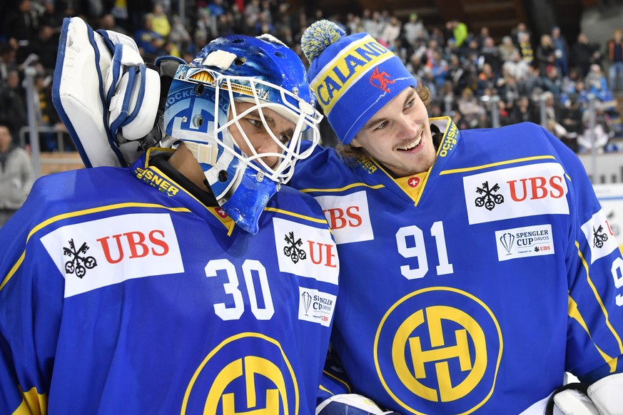 Davos&#039; Joren van Pottelberghe, left, and goalkeeper Gilles Senn celebrate after winning the game between HC Davos and Mountfield HK at the 91th Spengler Cup ice hockey tournament in Davos, Switze ...