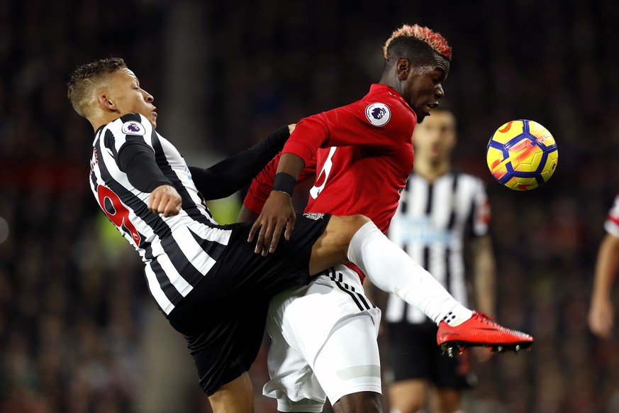 Newcastle United&#039;s Dwight Gayle, left, and Manchester United&#039;s Paul Pogba battle for the ball during their English Premier League soccer match at Old Trafford, Manchester, England, Saturday, ...
