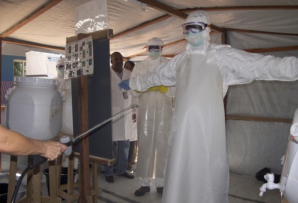epa04493026 A photograph made availabe on 17 November 2014 shows health workers from Mali getting sprayed with disinfectant at the Ebola isolation centre that was inaugurated on the grounds of the for ...