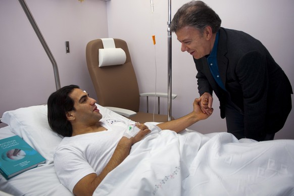 epa04041606 Colombian president Juan Manuel Santos (R) during his visit to Colombian soccer player Radamel &#039;Falcao&#039; Garcia (L) who recovers from a knee surgery at Trinidade Hospital in Porto ...