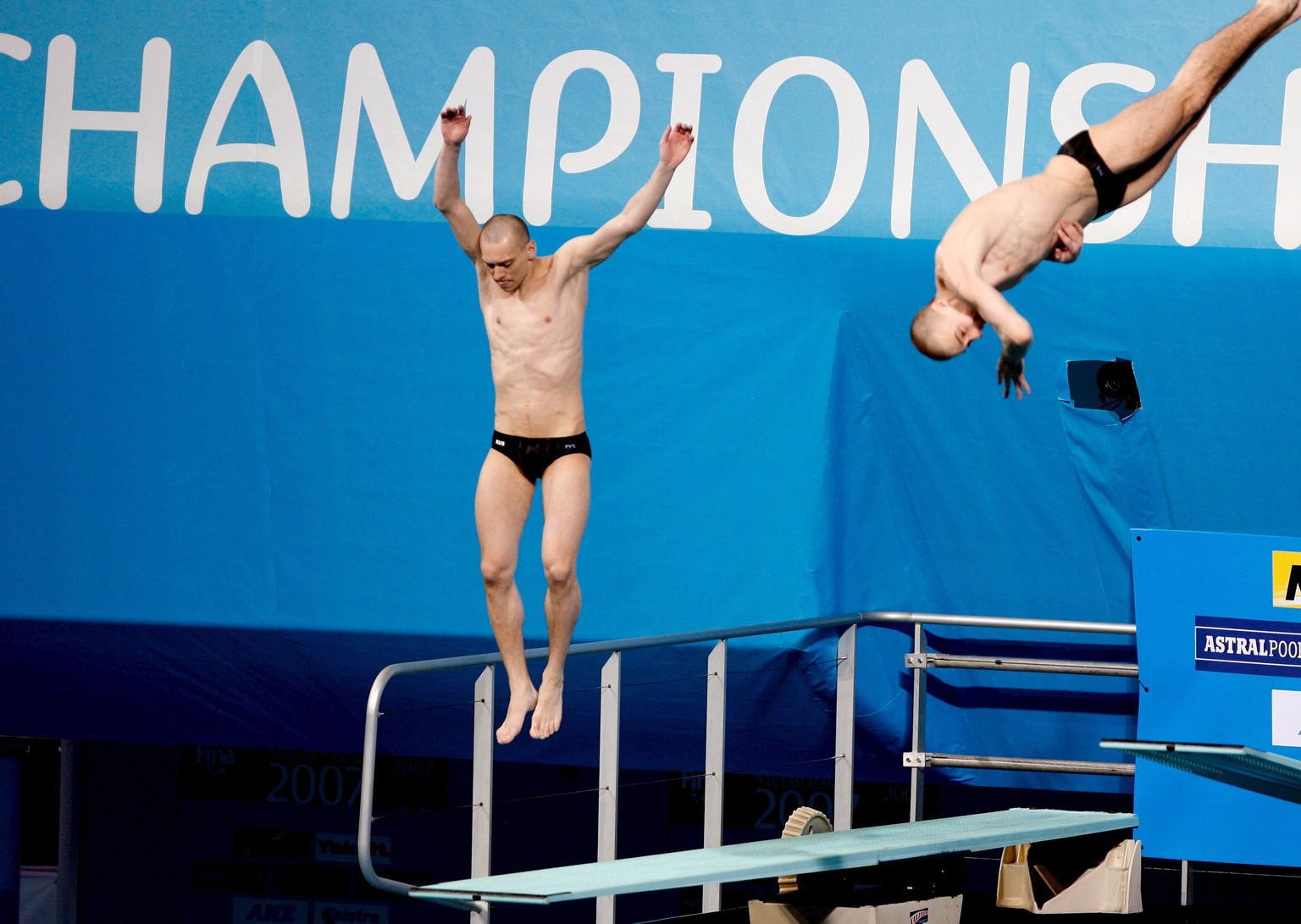 epa00960762 Russian diver Aleksander Dobroskok jumps but fails to dive a his synchronised diving partner Gleb Galperin (R) dives dashing their lead in the men&#039;s 3m synchro springboard finals at t ...