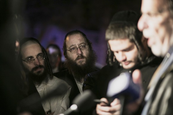 Orthodox Jewish people listen to N.Y. state Assemblyman Dov Hikind speak in Monsey, N.Y., Sunday, Dec. 29, 2019, following a stabbing late Saturday during a Hanukkah celebration. A man attacked the ce ...