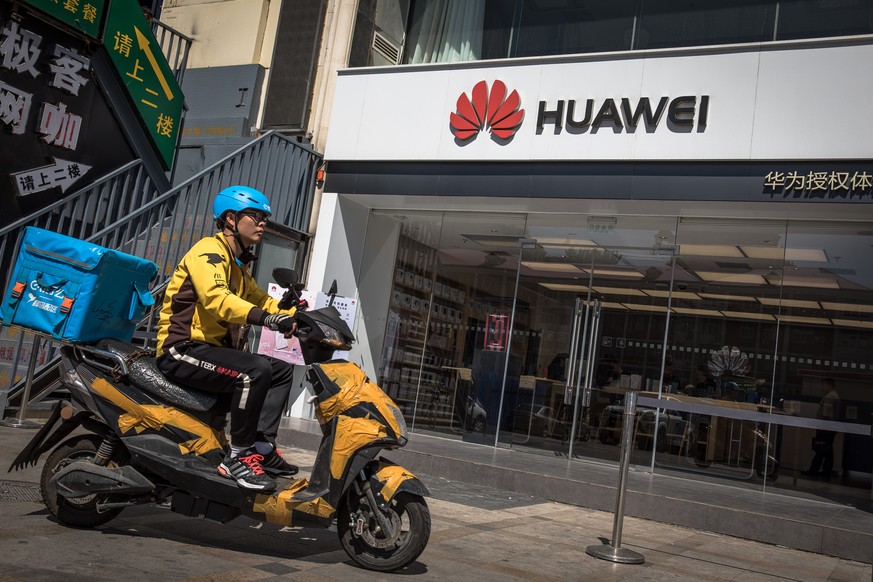 epa07586414 A delivery man rides on a scooter past a Huawei store in Beijing, China, 20 May 2019. According to media reports on 20 May 2019, the US based multinational technology company Google halted ...