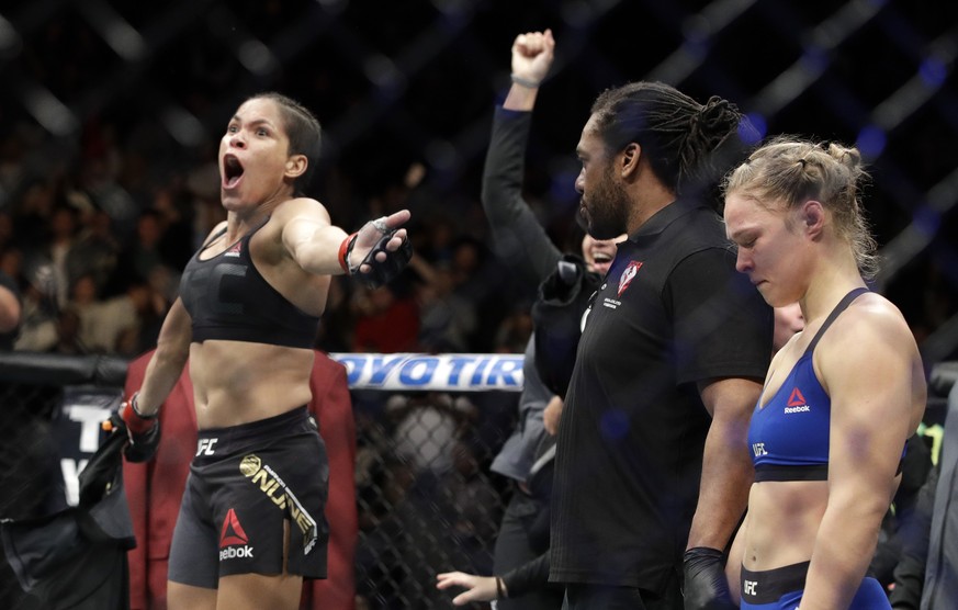 Amanda Nunes, left, celebrates her win as Ronda Rousey stands at right, after their women&#039;s bantamweight championship mixed martial arts bout was stopped in the first round at UFC 207, Friday, De ...
