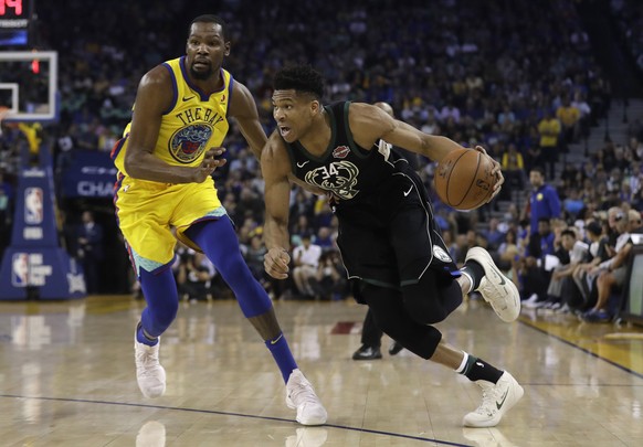 Milwaukee Bucks&#039; Giannis Antetokounmpo, right, drives past Golden State Warriors&#039; Kevin Durant during the first half of an NBA basketball game Thursday, March 29, 2018, in Oakland, Calif. (A ...
