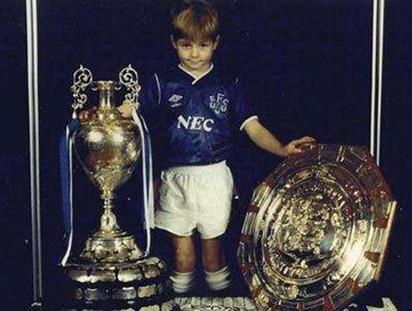 Hätten Sie den Knirps erkannt? Steven Gerrard wurde als Siebenjähriger von seinem Vater dazu gezwungen, sich in ein Everton-Dress zu stürzen und mit dem Meisterpokal zu posieren. Die Begeisterung steh ...