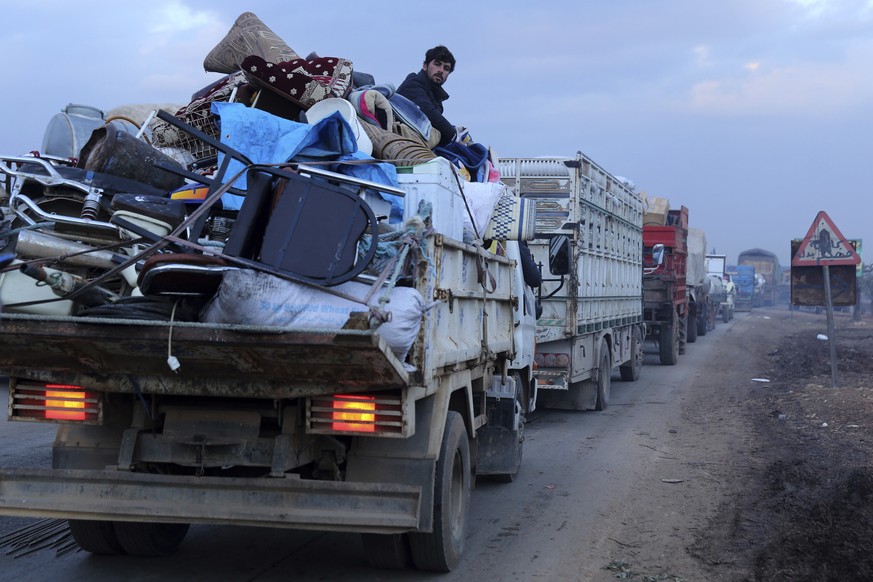 A man rides in a truck as civilians flee a Syrian military offensive in Idlib province on the main road near Hazano, Syria, Tuesday, Dec. 24, 2019. Syrian forces launched a wide ground offensive last  ...