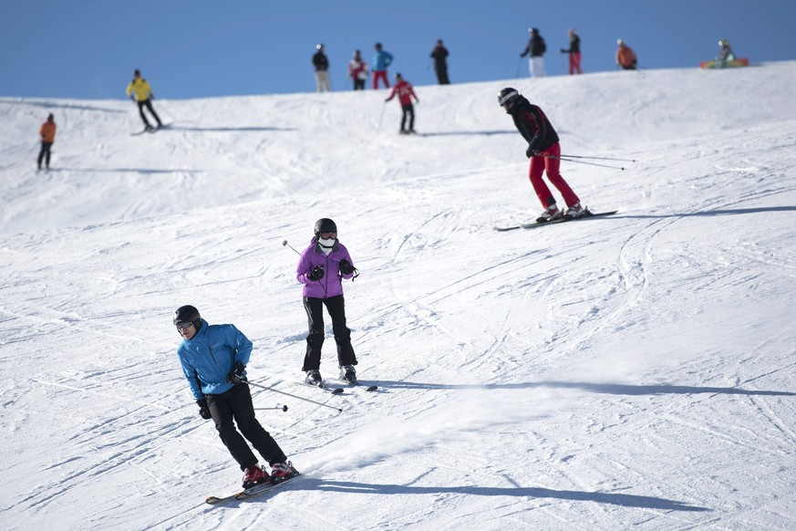 epa04628626 Ski enthusiasts enjoy a day on the slope in the Davos Klosters Ski resort in Davos, Switzerland, 20 February 2015. EPA/GIAN EHRENZELLER