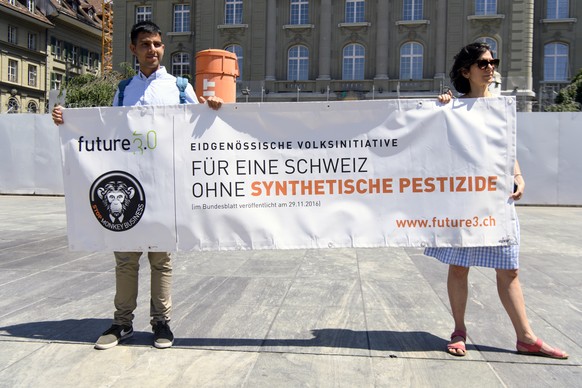 Zwei Personen mit einem Spruchband waehrend der Einreichung der Unterschriftenboegen der Initiative &quot;Fuer eine Schweiz ohne synthetische Pestizide&quot; bei der Bundeskanzlei, am Freitag, 25. Mai ...