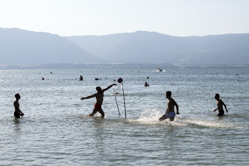 People play in the water of the Lac de Neuchatel to cool off during the sunny and warm weather, in Gletterens, Switzerland, Friday, June 28, 2019. The forecast predicts hot weather in Switzerland with ...