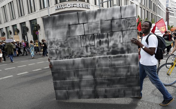 epa06021204 Two demonstrators carry a cardboard wall during a protest march against the G20-Africa Conference that takes place in Berlin next week, in Berlin, Germany, 10 June 2017. A few hundred demo ...