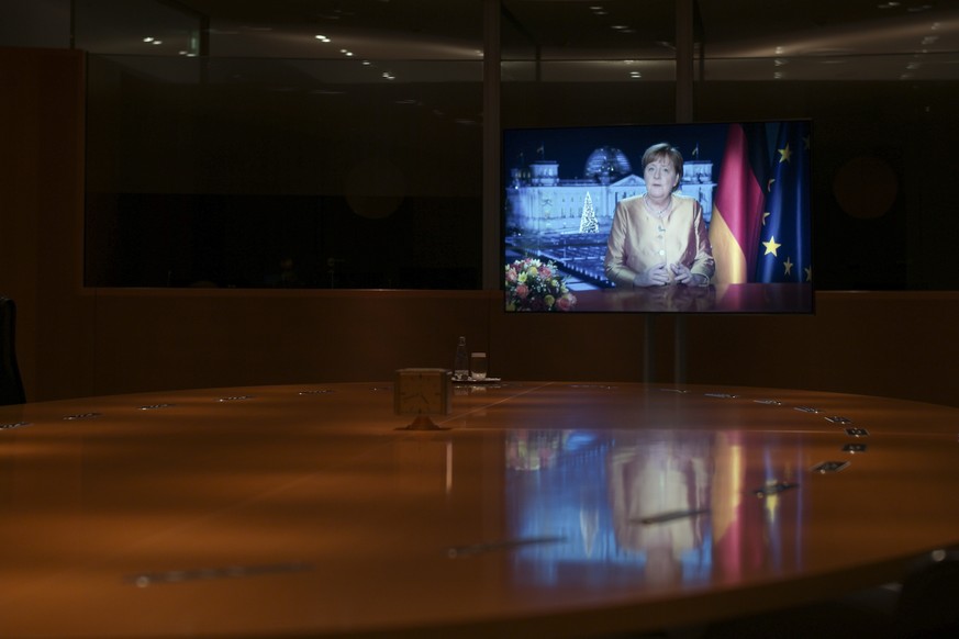 epa08911976 German Chancellor Angela Merkel displayed on a screen during the television recording of her annual New Year&#039;s speech at the chancellery in Berlin, Germany, 30 December 2020 (Issued 3 ...