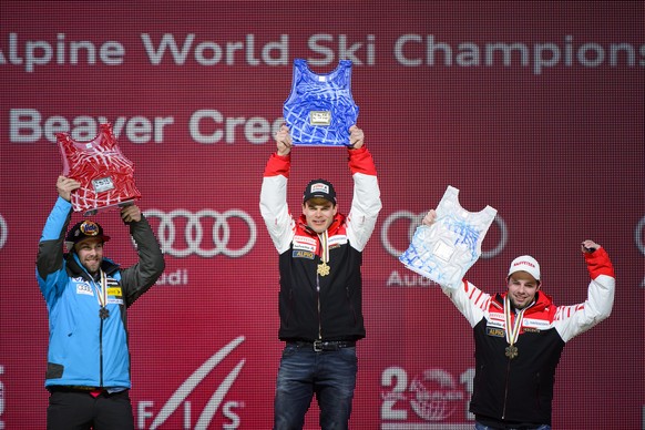 Travis Ganong of the USA, left, silver medal, Patrick Kueng of Switzerland, center, gold medal, Beat Feuz of Switzerland, right, bronze medal, celebrates during the men&#039;s downhill medal ceremony  ...
