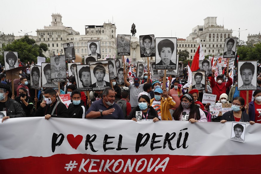 epa09221789 Relatives of victims of La Cantuta and other massacres perpetrated during the Government of Alberto Fujimori, show pictures of their loved ones during march against the right-wing presiden ...