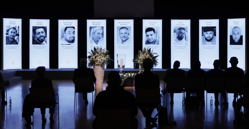 epa09024410 Participants sit in front of the portraits of the victims, during a memorial ceremony for the anniversary of the shooting by a right-wing extremist in February 2020, in Hanau, Germany, 19  ...