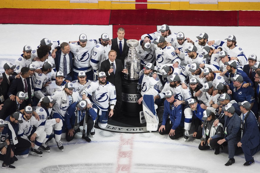 Tampa Bay Lightning players surround NHL Commissioner Gary Bettman as they celebrate after defeating the Dallas Stars to win the Stanley Cup in Edmonton, Alberta, on Monday, Sept. 28, 2020. (Jason Fra ...