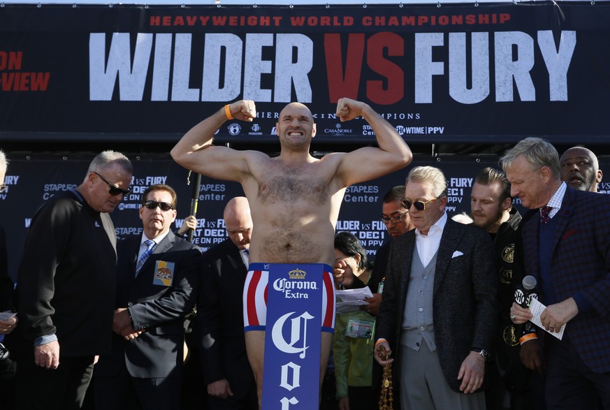 Boxer Tyson Fury flexes during his official weigh-in ceremony Friday, Nov. 30, 2018, at Staples Center in Los Angeles ahead of his Saturday bout against WBC heavyweight titleholder boxer Deontay Wilde ...