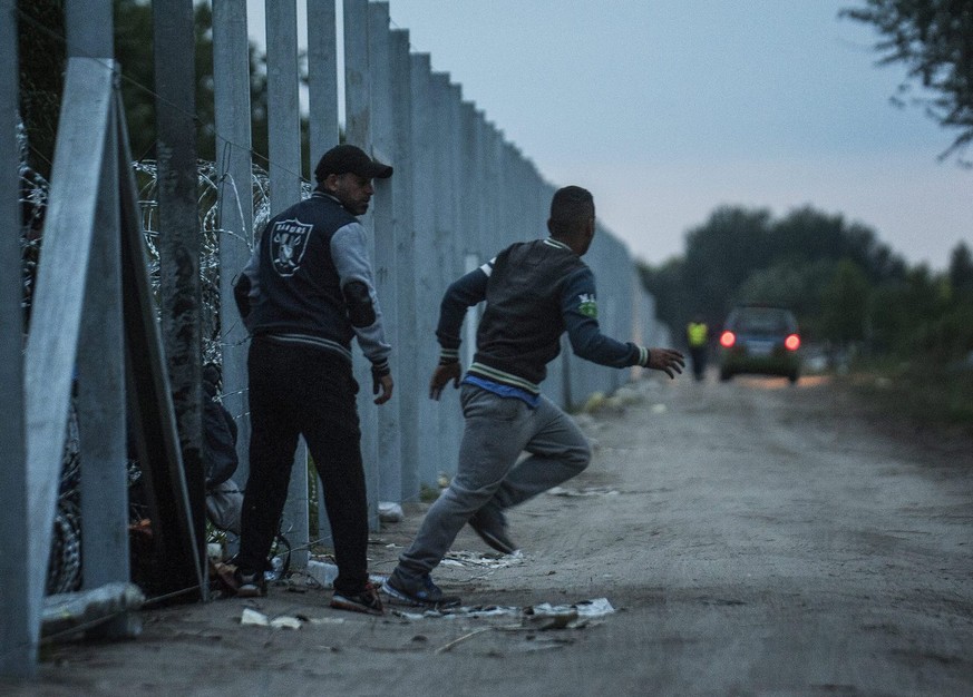 epa04990657 YEARENDER 2015 SEPTEMBER..Migrants enter Hungary from Serbia at a temporary border fence under construction near the border village of Roszke, some 180 km southeast of Budapest, Hungary, e ...