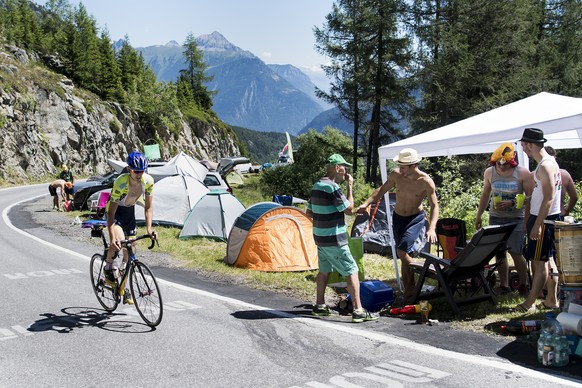 A rider makes his way on the race road next to camping car one day before the 17th stage of the 103rd edition of the Tour de France cycling race over 184,5km between Bern and Finhaut-Emosson in Switze ...