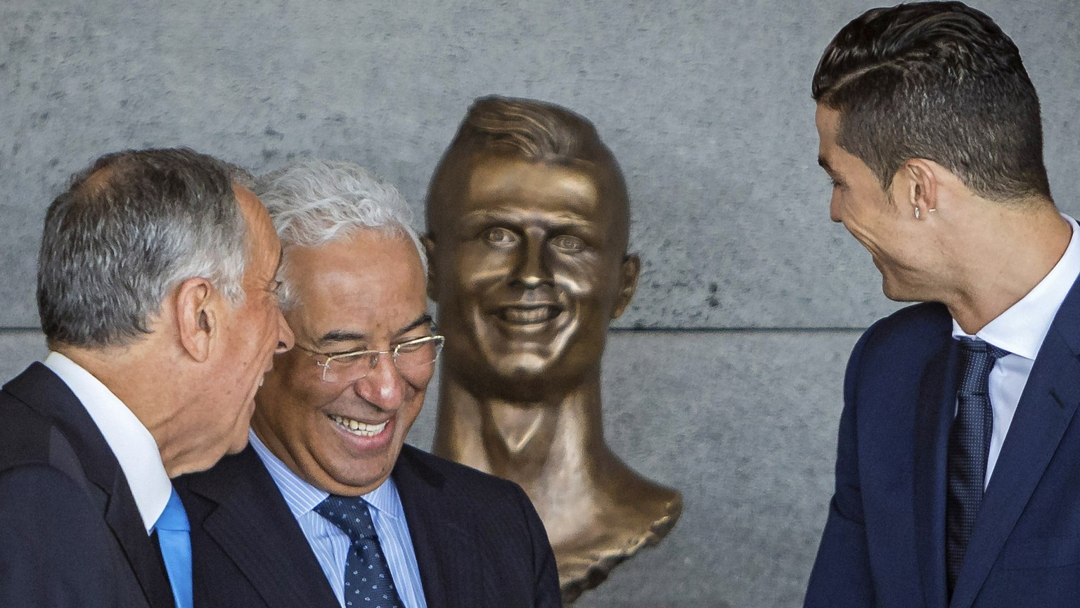 epa05877458 (L-R) Portuguese President Marcelo Rebelo de Sousa, Portuguese Prime Minister Antonio Costa, and Portuguese soccer player Cristiano Ronaldo share a light moment in front of a Ronaldo bust  ...
