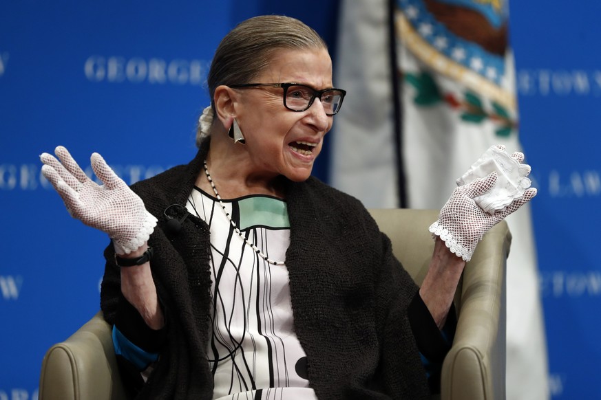 In this Sept. 20, 2017 photo, U.S. Supreme Court Justice Ruth Bader Ginsburg reacts to applause as she is introduced by William Treanor, Dean and Executive Vice President of Georgetown University Law  ...