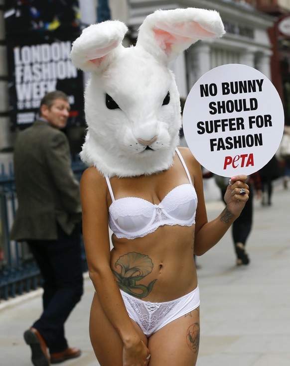 A model wears a rabbit head and holds a banner during a protest against the use of fur, outside Somerset House in London, Thursday, Sept. 11, 2014. &quot;Every day, gentle rabbits are bludgeoned, elec ...