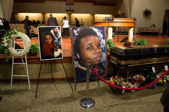 epa04367699 Photographs surround the casket of Michael Brown before the start of his funeral at the Friendly Temple Missionary Baptist Church, St Louis, Missouri, USA, 25 August 2014. Eighteen-year ol ...