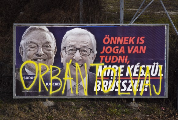 FILE- In this Feb. 26, 2019, file photo, a billboard from a campaign of the Hungarian government showing EU Commission President Jean-Claude Juncker and Hungarian-American financier George Soros with  ...